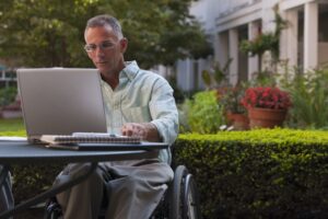 Chicago Social Security Disability Lawyer  Businessman with spinal cord injury working on a laptop